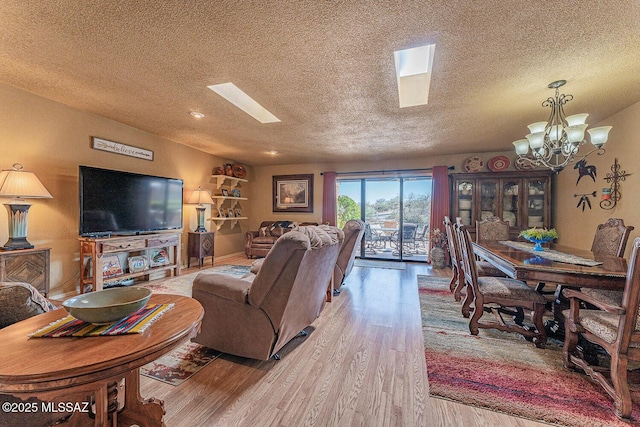 living room with a textured ceiling, an inviting chandelier, and wood finished floors