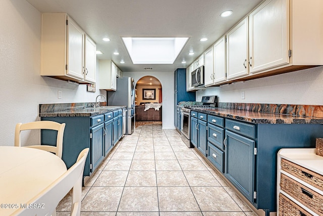 kitchen with blue cabinetry, dark countertops, recessed lighting, stainless steel appliances, and light tile patterned floors