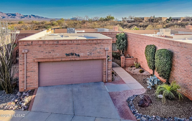 view of front of property featuring a mountain view, driveway, and fence