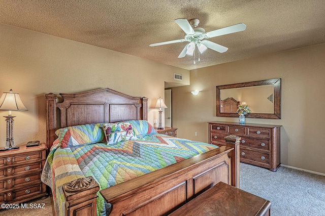 carpeted bedroom featuring visible vents, baseboards, a textured ceiling, and a ceiling fan