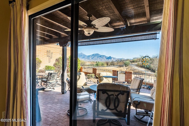 view of patio / terrace with a balcony, a mountain view, and ceiling fan