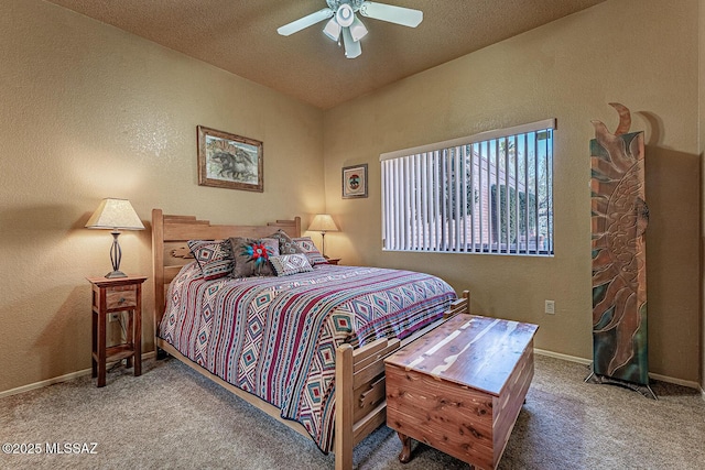 bedroom with a textured wall, ceiling fan, and carpet floors