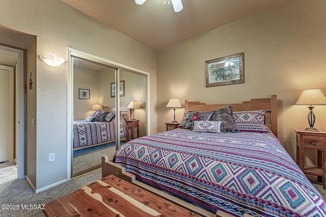 carpeted bedroom featuring baseboards, a textured wall, a closet, a textured ceiling, and a ceiling fan