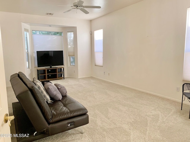 living room featuring visible vents, ceiling fan, baseboards, and carpet