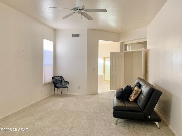 sitting room featuring visible vents, baseboards, carpet, and a ceiling fan