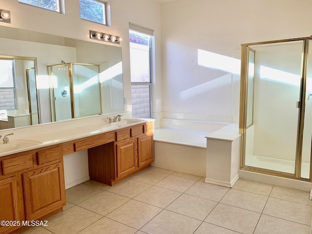 bathroom with tile patterned floors, a bath, a stall shower, and a sink