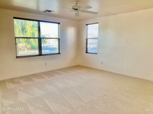 unfurnished room featuring visible vents, light carpet, and ceiling fan