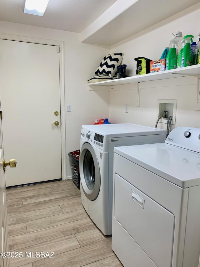 clothes washing area featuring laundry area, independent washer and dryer, and light wood-type flooring