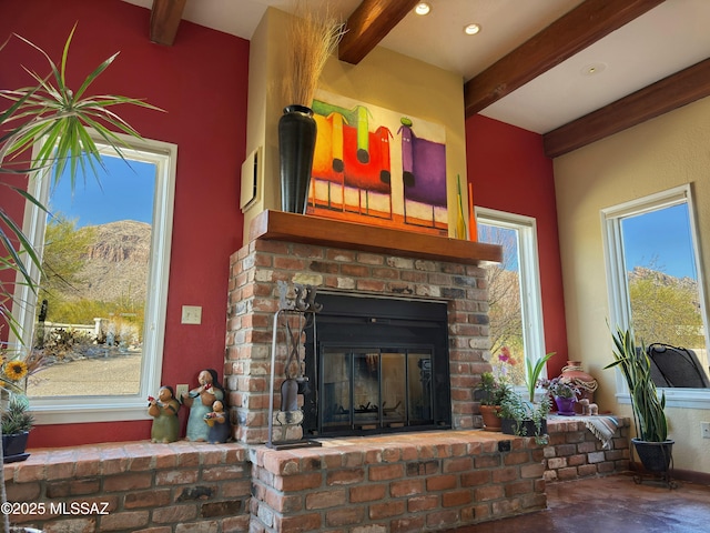 interior details featuring beamed ceiling and a brick fireplace