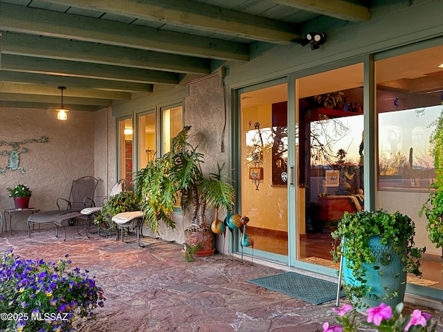 property entrance with a patio area and stucco siding