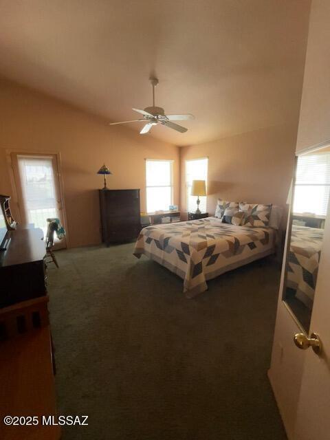 carpeted bedroom with a ceiling fan and vaulted ceiling