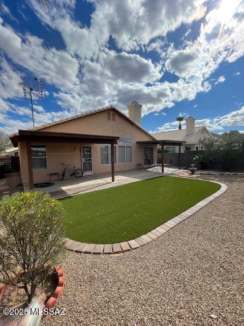 back of house featuring stucco siding, a chimney, and a patio