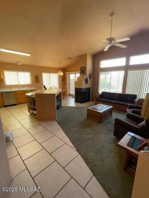 living room with ceiling fan, light tile patterned flooring, and vaulted ceiling