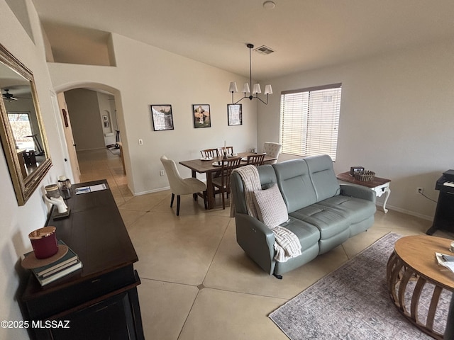 living room with lofted ceiling, visible vents, arched walkways, and baseboards