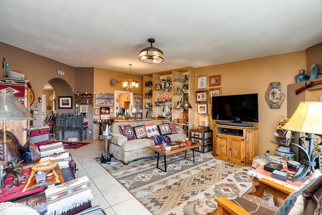 living room featuring arched walkways, a chandelier, and tile patterned floors