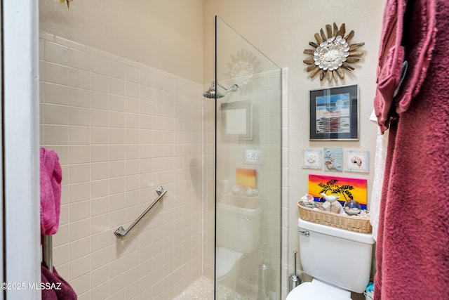 full bath featuring tiled shower and toilet