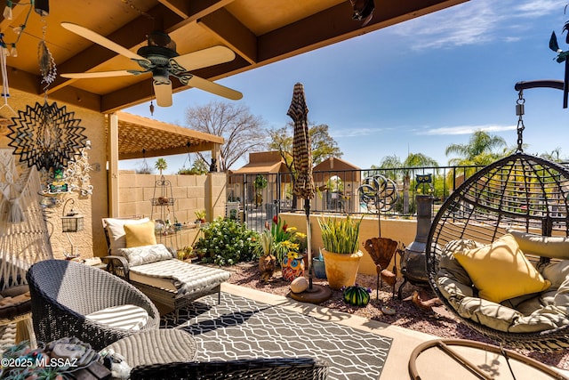 view of patio featuring a ceiling fan and fence