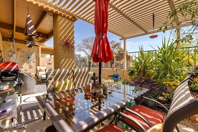 view of patio featuring outdoor dining area, fence, ceiling fan, and a pergola