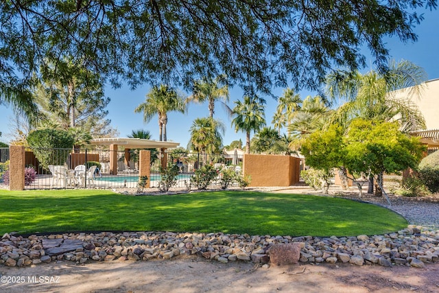 view of yard featuring fence and an outdoor pool