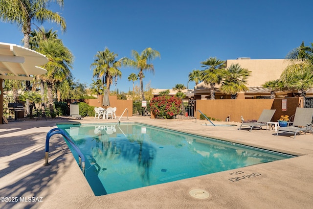 community pool featuring a patio and fence