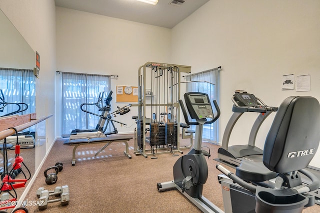 exercise area with visible vents and a high ceiling