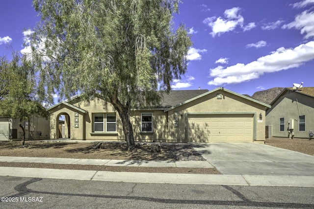 ranch-style house featuring a garage, driveway, and stucco siding