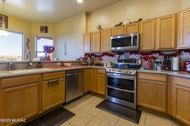 kitchen featuring a sink, decorative light fixtures, appliances with stainless steel finishes, light countertops, and light tile patterned floors