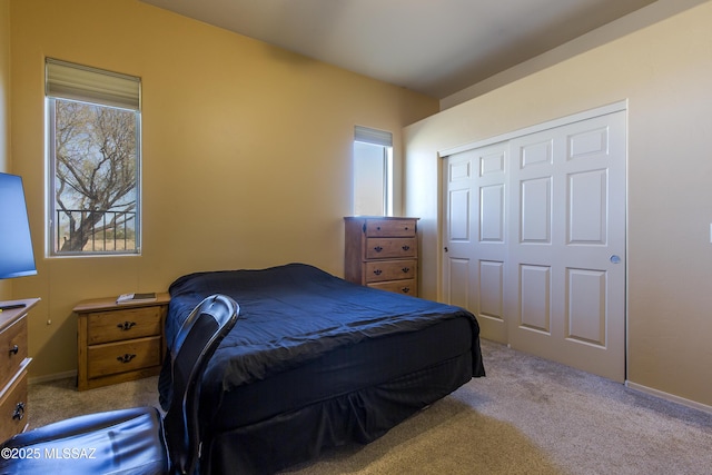 bedroom with a closet, carpet floors, and baseboards