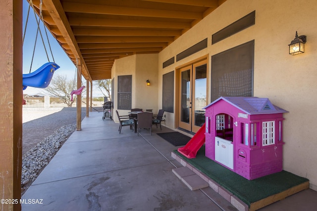 view of patio / terrace featuring outdoor dining space, area for grilling, french doors, and fence