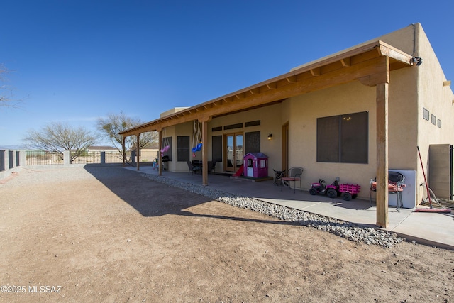 back of property with a patio area, fence, and stucco siding