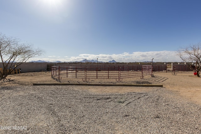 view of yard featuring a rural view, a mountain view, an enclosed area, and fence