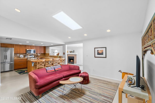 living room with recessed lighting, visible vents, baseboards, and a lit fireplace