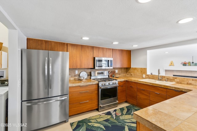 kitchen featuring a sink, light countertops, brown cabinets, and stainless steel appliances
