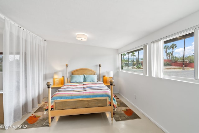 bedroom featuring concrete flooring and baseboards