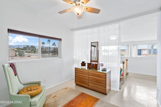 bedroom featuring ceiling fan, concrete flooring, and baseboards
