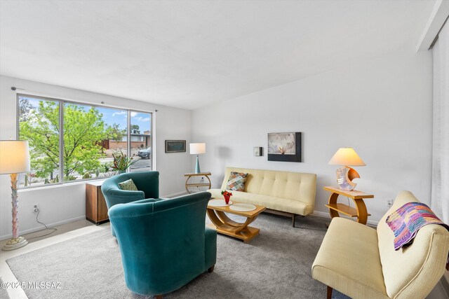 carpeted living room featuring baseboards