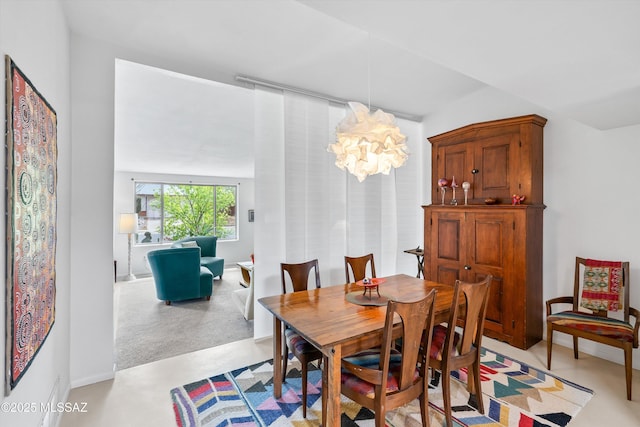 dining space featuring a notable chandelier and concrete flooring