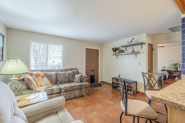 tiled living room with visible vents and baseboards