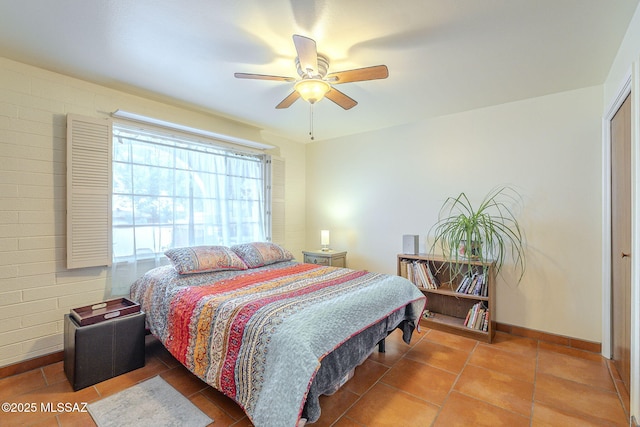 tiled bedroom with baseboards and ceiling fan