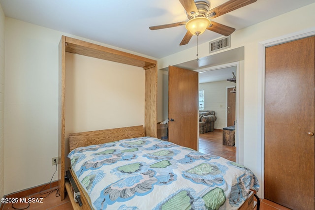 bedroom featuring tile patterned floors, visible vents, and a ceiling fan