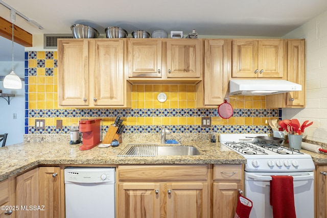 kitchen featuring decorative backsplash, white appliances, under cabinet range hood, and a sink