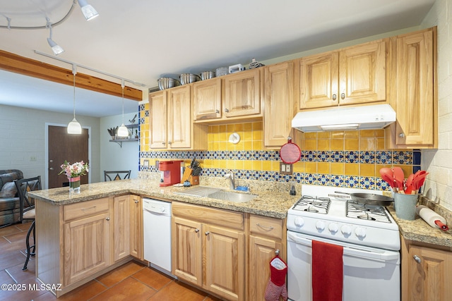 kitchen featuring under cabinet range hood, a sink, tasteful backsplash, white appliances, and a peninsula