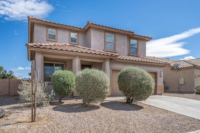 mediterranean / spanish house featuring concrete driveway, fence, and stucco siding