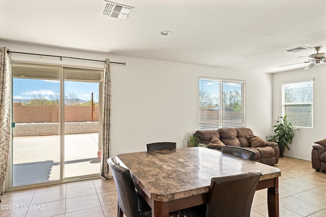 dining space with light tile patterned floors, visible vents, and ceiling fan
