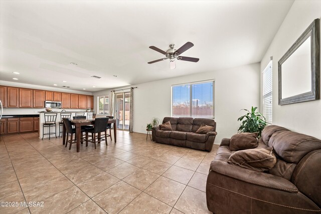 living area with light tile patterned floors, visible vents, recessed lighting, and ceiling fan