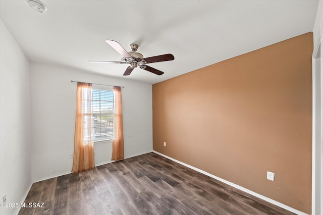 spare room featuring baseboards, ceiling fan, and dark wood-style flooring
