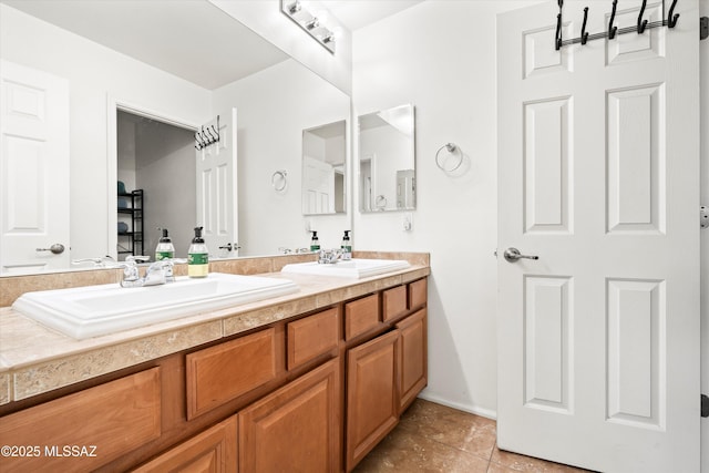 full bath with double vanity, tile patterned floors, and a sink