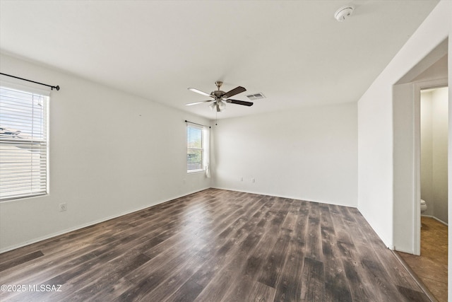 spare room with ceiling fan, visible vents, and wood finished floors