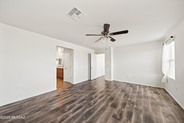 unfurnished room with visible vents, a ceiling fan, and dark wood-style flooring