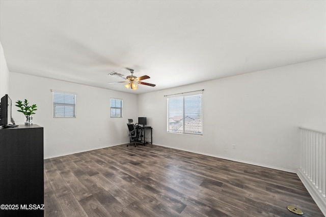 empty room with dark wood-style floors, visible vents, and a ceiling fan